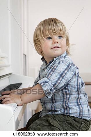 A boy toddler sitting at a piano View Large Photo Image Stock Photo - A boy toddler sitting at a piano. Fotosearch