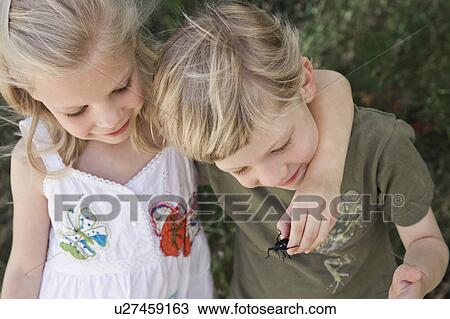 Stock Image - A brother and sister with a beetle. Fotosearch
