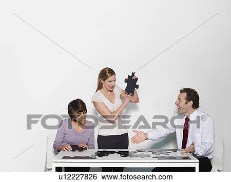 A business trio doing a jigsaw View Large Photo Image Stock Photograph - A business trio doing a jigsaw. Fotosearch