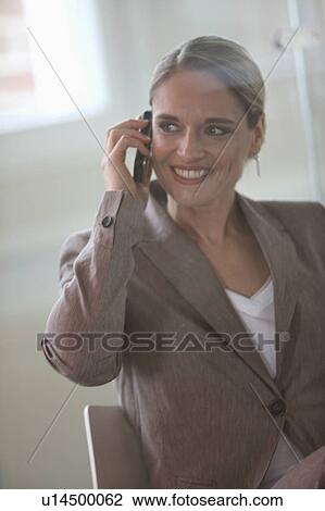 Stock Image - A businesswoman with cell-phone. Fotosearch