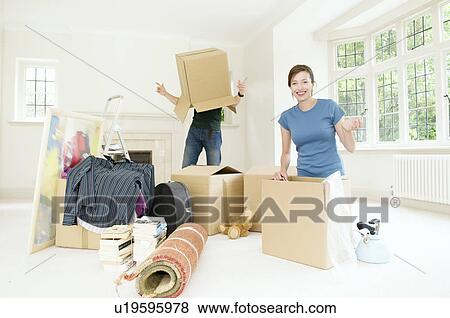 Stock Photo - A couple having fun moving home. Fotosearch
