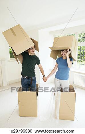 Stock Image - A couple having fun with boxes. Fotosearch