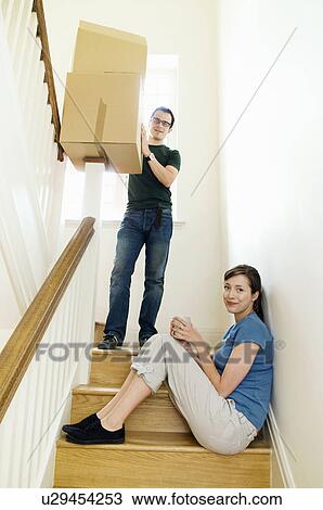 Stock Image - A couple on the stairs with boxes. Fotosearch