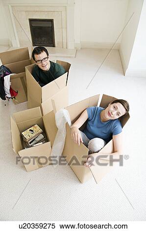 Stock Photography - A couple sitting in cardboard boxes. Fotosearch