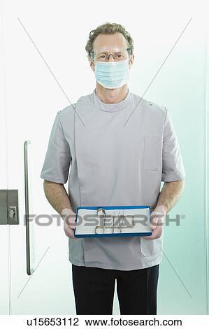 A dentist holding his tools View Large Photo Image Stock Image - A dentist holding his tools. Fotosearch