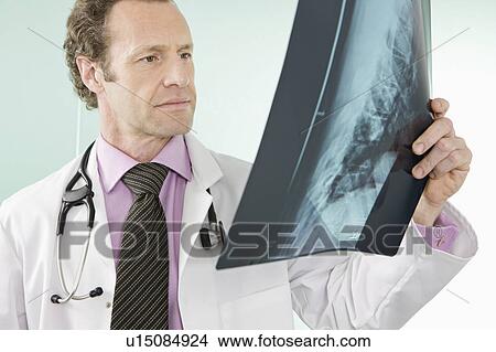 A doctor holding an x-ray View Large Photo Image Picture - A doctor holding an x-ray. Fotosearch