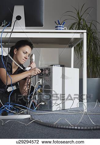 A female angrily fixing her computer View Large Photo Image Stock Image - A female angrily fixing her computer. Fotosearch