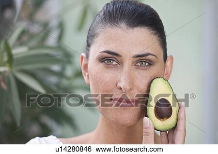 A female beauty holding an avocado View Large Photo Image Stock Photograph - A female beauty holding an avocado. Fotosearch