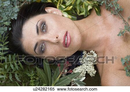 Stock Photography - A female beauty surrounded in foliage. Fotosearch