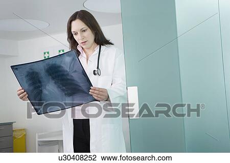 Stock Image - A female doctor checking an x-ray. Fotosearch