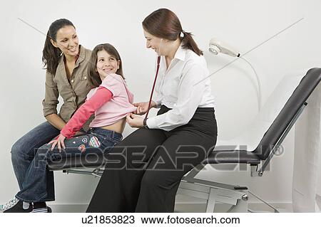 A female doctor looking at a young girl View Large Photo Image Stock Image - A female doctor looking at a young girl. Fotosearch