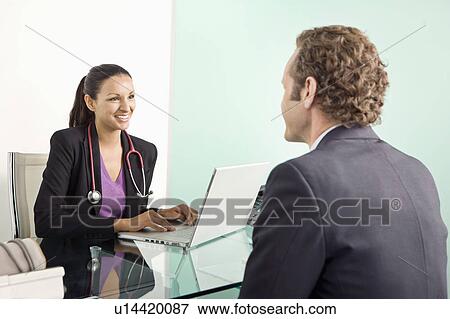 A female doctor with a male patient View Large Photo Image Stock Photo - A female doctor with a male patient. Fotosearch