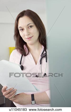 Stock Image - A female doctor with some notes. Fotosearch