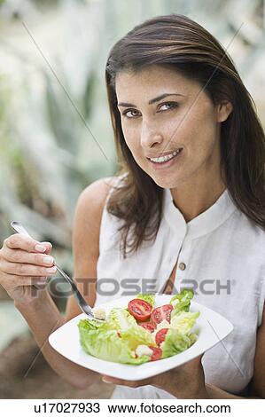 A female eating salad outside View Large Photo Image Stock Image - A female eating salad outside. Fotosearch