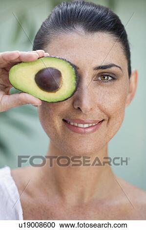 Stock Image - A female holding half an Avocado. Fotosearch