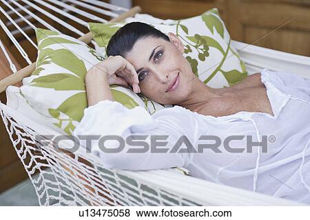 Stock Photo - A female relaxing in a hammock. Fotosearch