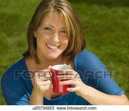 A female with a hot drink on a lawn View Large Photo Image Stock Image - A female with a hot drink on a lawn. Fotosearch