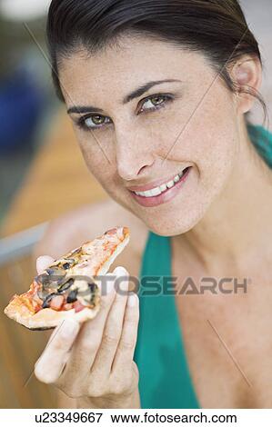 Stock Photo - A female with a piece of pizza. Fotosearch