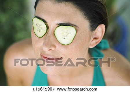 Stock Photo - A female with cucumber on her eyes. Fotosearch