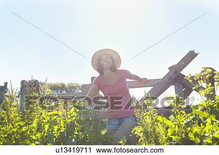 A girl climbing over a fence View Large Photo Image Stock Image - A girl climbing over a fence. Fotosearch