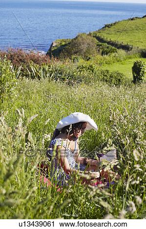 A girl in a field reading View Large Photo Image Stock Image - A girl in a field reading. Fotosearch