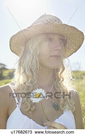 A girl in a field with a flower View Large Photo Image Stock Image - A girl in a field with a flower. Fotosearch