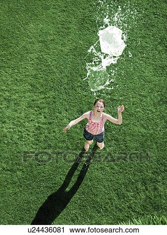 A girl looking up at a water balloon View Large Photo Image Stock Image - A girl looking up at a water balloon. Fotosearch