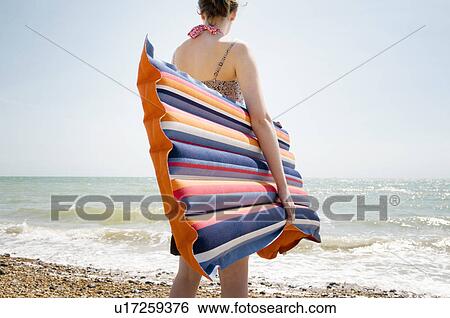 Stock Photograph - A girl with a Lilo at the beach. Fotosearch