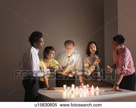 A group examining a lightbulb View Large Photo Image Stock Photography - A group examining a lightbulb. Fotosearch