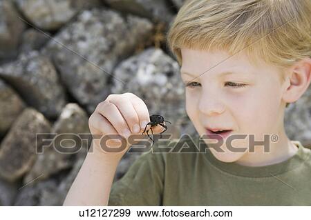 Stock Photo - A headshot of a boy with a beetle. Fotosearch