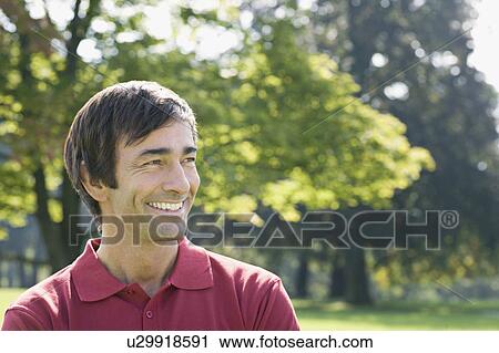 Stock Image - A middle aged man in a park. Fotosearch