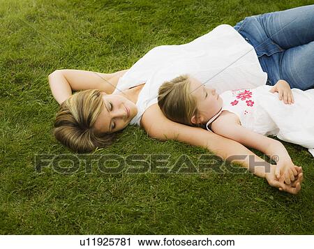 A mother and daughter lying on a lawn View Large Photo Image Stock Image - A mother and daughter lying on a lawn. Fotosearch
