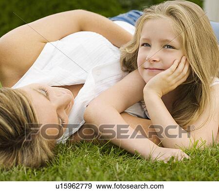 Stock Photo - A mother and daughter lying on a lawn. Fotosearch