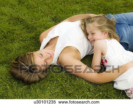 Stock Photography - A mother and daughter lying on a lawn. Fotosearch