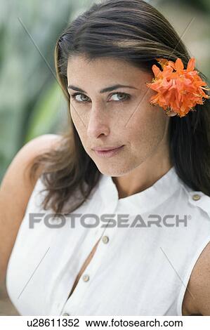 Stock Image - A portrait of a female with a flower. Fotosearch