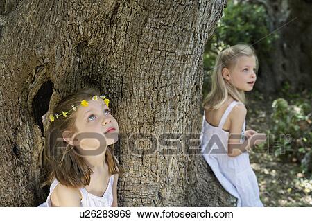 A portrait of two girls by a tree View Large Photo Image Stock Photo - A portrait of two girls by a tree. Fotosearch