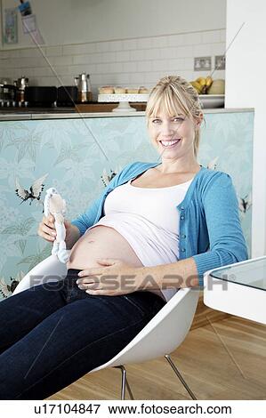 A pregnant mum holding a baby toy View Large Photo Image Stock Photo - A pregnant mum holding a baby toy. Fotosearch