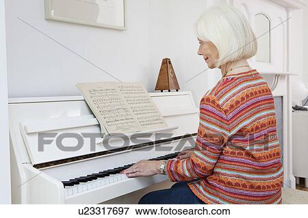Stock Photo - A senior female playing the piano. Fotosearch