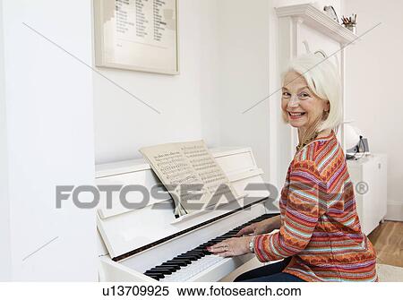 Stock Photography - A senior female playing the piano. Fotosearch