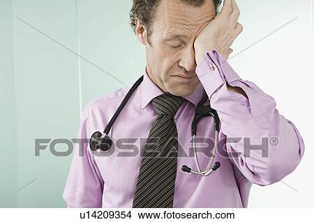 Picture - A tired doctor rubbing his eyes. Fotosearch