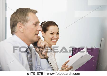Stock Image - A young business woman at work. Fotosearch