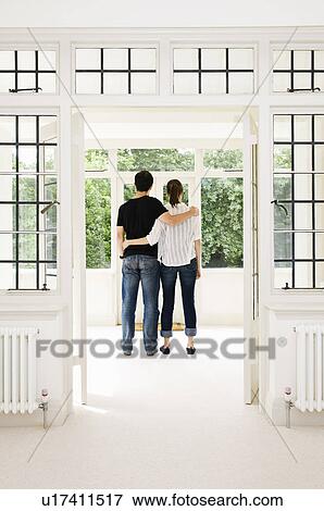 Stock Photo - A young couple looking out of the window. Fotosearch