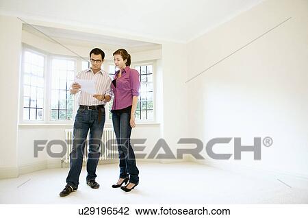 Stock Image - A young couple read a letter together. Fotosearch