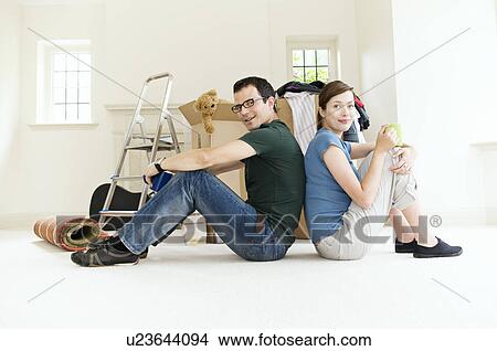 Picture - A young couple sitting back to back.. Fotosearch