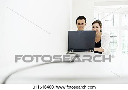 Stock Image - A young couple with a laptop. Fotosearch