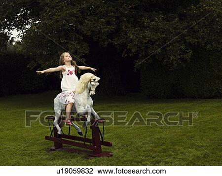 A young girl on a rocking horse View Large Photo Image Stock Image - A young girl on a rocking horse. Fotosearch