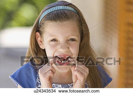 Picture - A young girl points to her missing teeth. Fotosearch