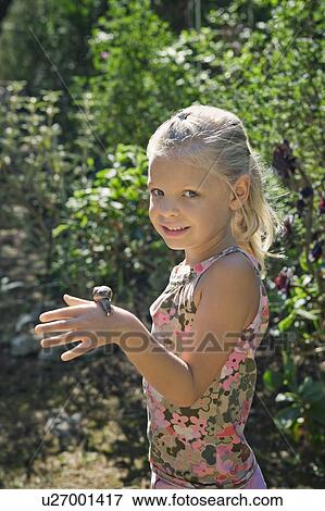 Stock Photo - A young girl with a snail. Fotosearch