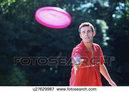 A young man playing Frisbee View Large Photo Image Stock Photo - A young man playing Frisbee. Fotosearch