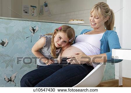 Stock Image - A young pregnant mum with her daughter. Fotosearch
